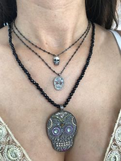 Kurzer silberner Anhänger in Form eines Totenkopfes mit Zirkonen besetzt.