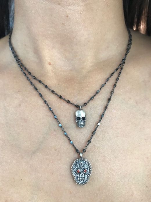 Kurzer silberner Anhänger in Form eines Totenkopfes mit Zirkonen besetzt.