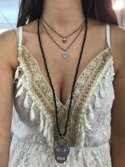 Kurzer silberner Anhänger in Form eines Totenkopfes mit Zirkonen besetzt.